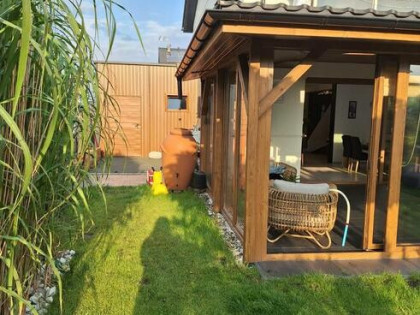 Dom szczytowy z ogrodem zimowym i garażem.