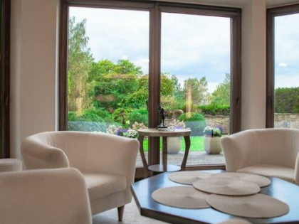 Dom pod maistem zatopiony w zieleni.