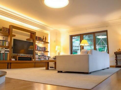 Ein Haus vor den Toren der Stadt, umgeben von vie.